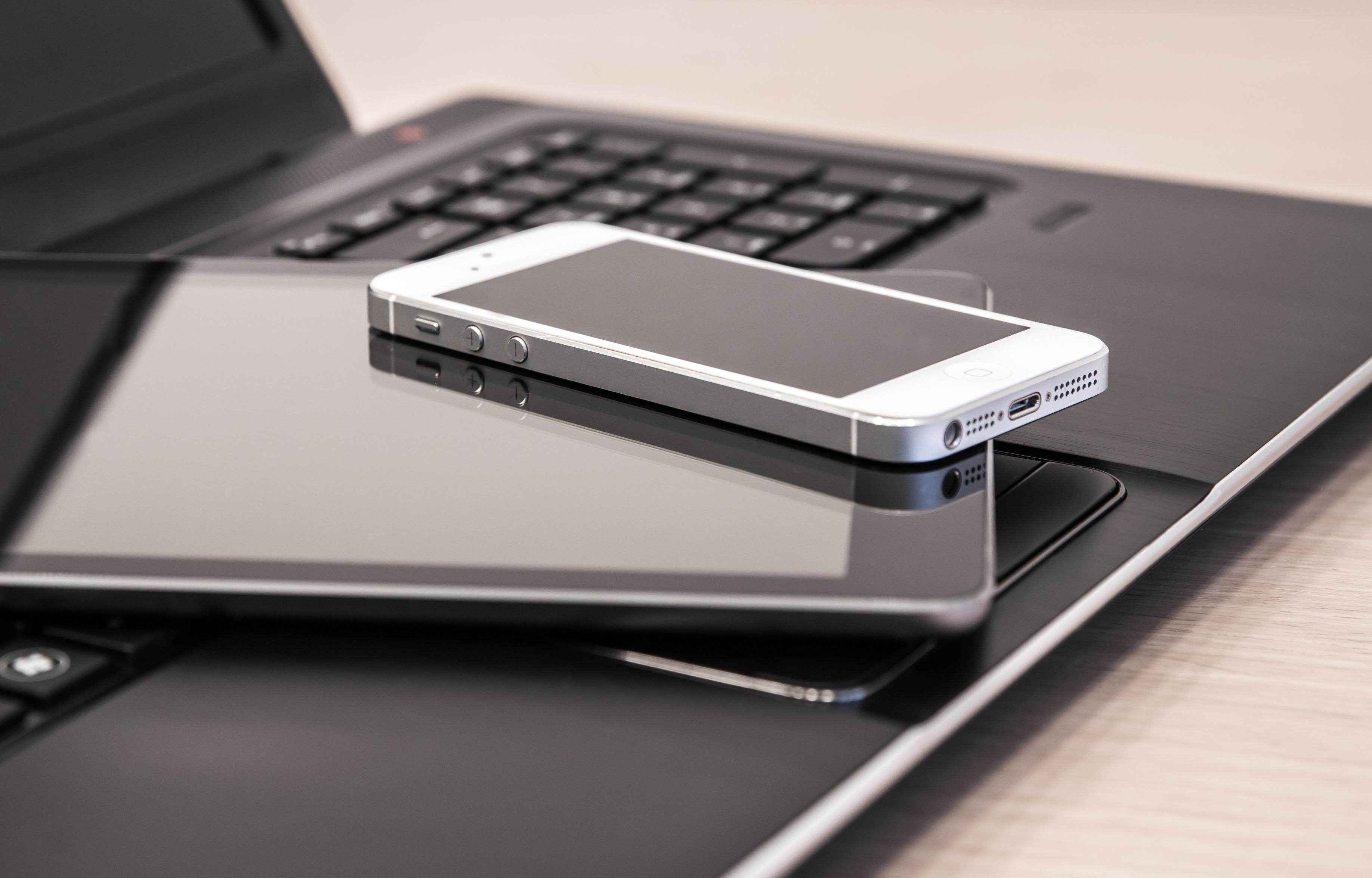 Affordable Connectivity Program - laptop with tablet and smart phone stacked on top